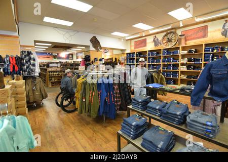 Un uomo della generazione Z che naviga attraverso un negozio di abbigliamento occidentale, il Wrangler, nel centro di Cheyenne Wyoming nell'agosto 2021 Foto Stock