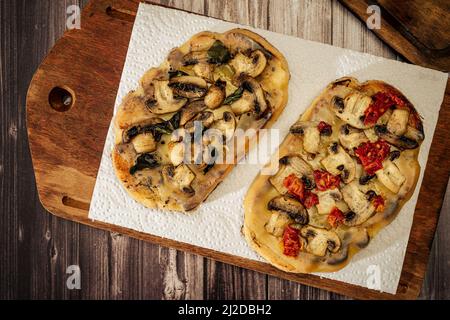 Bruschette grandi con formaggio, funghi, prosciutto e pomodoro in diverse combinazioni. Cucina mediterranea. Vista dall'alto Foto Stock