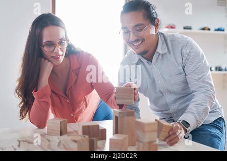 Niente guida il cambiamento come l'innovazione. Shot di un giovane uomo d'affari e di una donna d'affari che hanno un incontro con i blocchi di costruzione in un ufficio moderno. Foto Stock