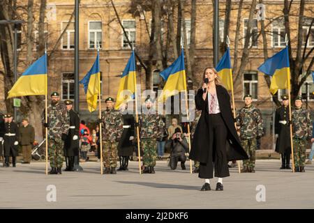 Bandiere di Ucraina durante una cerimonia a Vilnius con soldati e bella cantante ucraino cantare inno nazionale Foto Stock