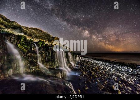 Osmington Mills, Dorset, Regno Unito. 1st aprile 2022. Meteo Regno Unito. La Via Lattea brillantemente nel freddo cielo notturno limpido sopra una cascata sulla spiaggia di Osmington Mills vicino a Weymouth sulla Costa Dorset Jurassic. Picture Credit: Graham Hunt/Alamy Live News Foto Stock