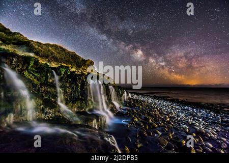 Osmington Mills, Dorset, Regno Unito. 1st aprile 2022. Meteo Regno Unito. La Via Lattea brillantemente nel freddo cielo notturno limpido sopra una cascata sulla spiaggia di Osmington Mills vicino a Weymouth sulla Costa Dorset Jurassic. Picture Credit: Graham Hunt/Alamy Live News Foto Stock