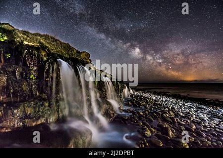 Osmington Mills, Dorset, Regno Unito. 1st aprile 2022. Meteo Regno Unito. La Via Lattea brillantemente nel freddo cielo notturno limpido sopra una cascata sulla spiaggia di Osmington Mills vicino a Weymouth sulla Costa Dorset Jurassic. Picture Credit: Graham Hunt/Alamy Live News Foto Stock