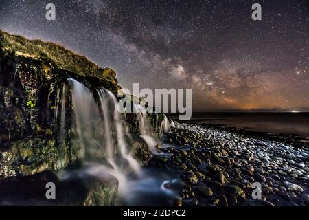 Osmington Mills, Dorset, Regno Unito. 1st aprile 2022. Meteo Regno Unito. La Via Lattea brillantemente nel freddo cielo notturno limpido sopra una cascata sulla spiaggia di Osmington Mills vicino a Weymouth sulla Costa Dorset Jurassic. Picture Credit: Graham Hunt/Alamy Live News Foto Stock