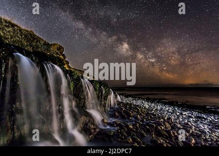 Osmington Mills, Dorset, Regno Unito. 1st aprile 2022. Meteo Regno Unito. La Via Lattea brillantemente nel freddo cielo notturno limpido sopra una cascata sulla spiaggia di Osmington Mills vicino a Weymouth sulla Costa Dorset Jurassic. Picture Credit: Graham Hunt/Alamy Live News Foto Stock