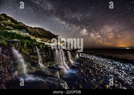 Osmington Mills, Dorset, Regno Unito. 1st aprile 2022. Meteo Regno Unito. La Via Lattea brillantemente nel freddo cielo notturno limpido sopra una cascata sulla spiaggia di Osmington Mills vicino a Weymouth sulla Costa Dorset Jurassic. Picture Credit: Graham Hunt/Alamy Live News Foto Stock