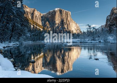 Impressione delle montagne che circondano la Valle di Yosemite, durante l'ora d'oro, che si riflettono nel fiume Merced. Foto Stock