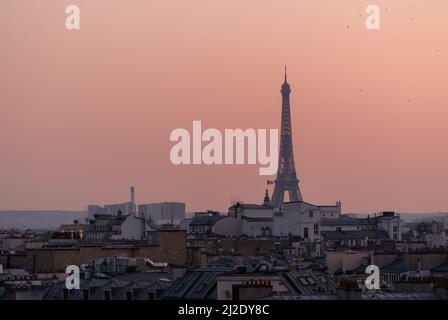 Vista della splendida Torre Eiffel sopra i tetti di Parigi e un bellissimo tramonto Foto Stock