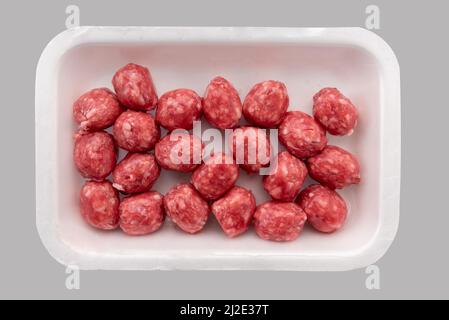 Polpette di manzo crudo in vassoio di plastica alimentare in vendita al supermercato, isolato su sfondo grigio chiaro, percorso di taglio, vista dall'alto Foto Stock