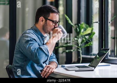 Lavoratore assetato, bevendo, prima di tornare al lavoro. Foto Stock