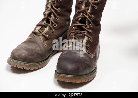 Stivali nubuck marroni - uno sporco, il secondo pulito su sfondo bianco. Cura delle scarpe. Foto Stock