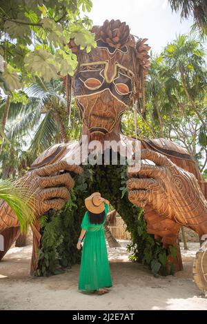 Scultura gigante di Daniel Popper chiamata Ven a la Luz, o entrando in luce, a Tulum, Messico, con una donna in abito verde in piedi davanti ad esso. Foto Stock