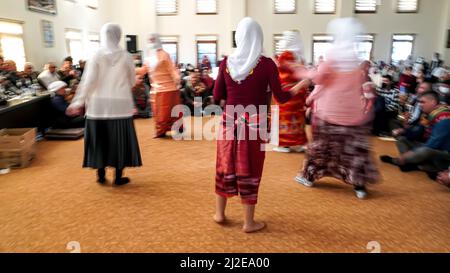 I musulmani Anatoliani Alevi si sono riuniti nei Djemevi di Izmir, in Turchia, il 25 marzo 2022 e hanno celebrato l'arrivo di Newroz primaverile con il 'Rito dell'unità'. Hanno pregato insieme in questa speciale messa officata dal leader religioso Alevi 'dde', eseguito dhikr ed eseguito danza religiosa che si chiama 'Semah' Foto Stock