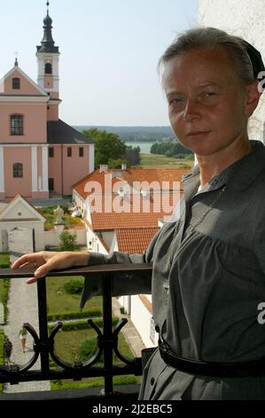 Wigry, Podlasie, Polonia, Polen, Polska, Ritratto di una suora sullo sfondo dell'ex monastero camaldolese. Portret zakonnicy zakonnica Foto Stock