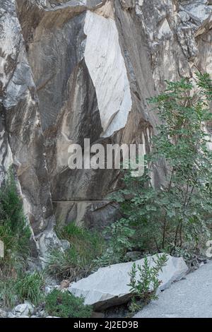 Particolare di una sezione recentemente staccata del Monte marmo di Carrara e del frammento rotto sul terreno, Carrara, Toscana - Italia. Foto Stock