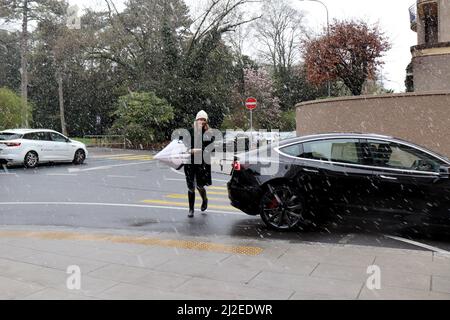 Ginevra, Svizzera, 2022-04-01 la donna attraversa la strada attraverso la neve. Il primo giorno di aprile è iniziato con il tempo del vino. Credit: marcio cimatti/Alamy Live News Foto Stock