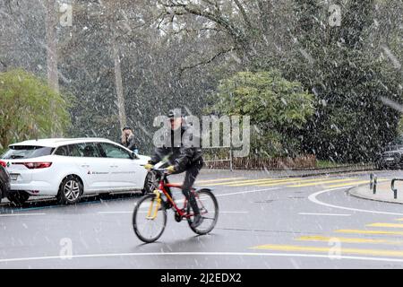 Ginevra, Svizzera, 2022-04-01 Rider sulla strada attraverso la neve. Il primo giorno di aprile è iniziato con il tempo del vino. Credit: marcio cimatti/Alamy Live News Foto Stock