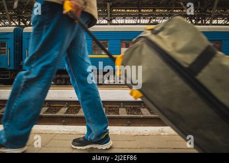 Persone che lasciano l'ucraina via treno a causa dell'invasione russa. Rifugiati che lasciano Lviv o Kiev, il treno di stato ucraino è visto sullo sfondo sullo statio Foto Stock
