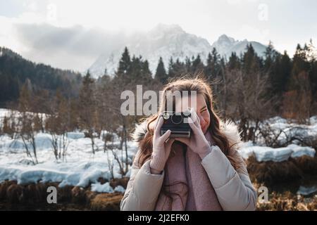 Giovane donna che fotografa con la macchina fotografica retrò Instant film per un'immagine in stile vintage. Foto Stock