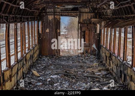 L'interno del vagone o del treno è bruciato. Vecchio vagone ferroviario dopo essere stato messo sul fuoco. Tutto l'interno è bruciato e irriconoscibile. Foto Stock
