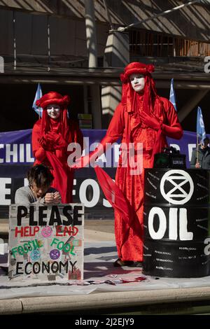 Edimburgo, Scozia, 1 aprile 2022. Gli attivisti climatici della Rebellion d'estinzione protestano fuori dal Parlamento scozzese il giorno in cui i prezzi dell'energia aumentano record nel Regno Unito. Gli attivisti, uno indossando una maschera del presidente russo Vladimir Putin, hanno messo in scena una moca fuoriuscita di petrolio fuori dall’edificio per protestare contro la continua dipendenza dai combustibili fossili. Photo credit: Jeremy Sutton-Hibbert/Alamy Live News. Foto Stock