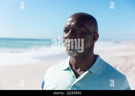 Fiducioso afro-americano pensionato anziano calvo uomo guardando via alla spiaggia in giorno di sole Foto Stock