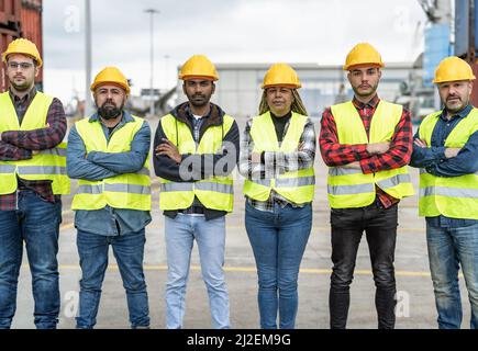 Team di ingegneri industriali diversi che lavorano in terminal logistico di container cargo Foto Stock