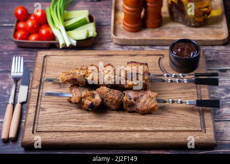 Shashlik russo tradizionale su spiedini con verdure. Carne di maiale alla griglia (shish kebab). Primo piano. Foto Stock