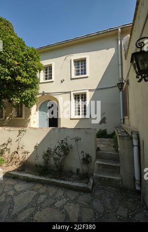 L'ingresso frontale in un cortile. L'albero arancione sulla sinistra è sacro. Presso la Sinagoga la Signoria di Izmir, Turchia. Foto Stock