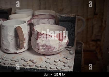 tazze di argilla in forno per la cottura di ceramica in studio di ceramica. Foto Stock