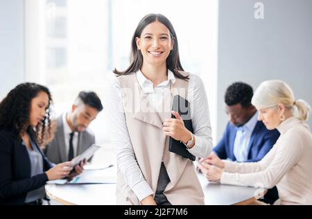 Portare il mio team alla grande. Shot di una giovane donna d'affari in un incontro con i suoi colleghi. Foto Stock