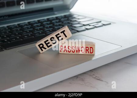 Reimpostare il testo della password sul cubo di legno posto sul portatile o sul notebook. Concetto di protezione tramite password. Foto Stock