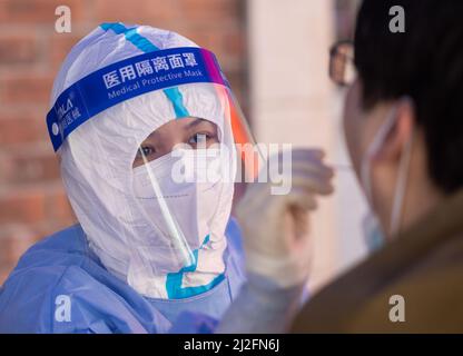 Shanghai. 1st Apr 2022. Un operatore medico preleva un campione di tampone da un residente per il test dell'acido nucleico nel distretto di Changning, Shanghai della Cina orientale, il 1 aprile 2022. Credit: Jin Liwang/Xinhua/Alamy Live News Foto Stock