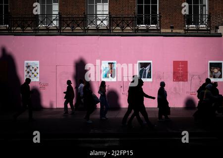 Londra, Regno Unito. 26 marzo 2022. Le persone in silhouette passano davanti a una costruzione che si accoccola su Oxford Street. Credito: Stephen Chung / Alamy Foto Stock
