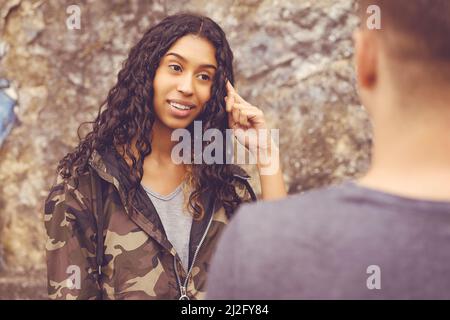 Elegante donna hipster sudamericana che parla con il ragazzo all'aperto in stile urbano Foto Stock