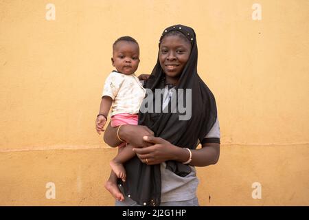 Felice cura West African Madre tenendo il suo carino bambino piccolo.maternità concetto. Foto Stock