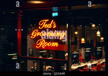 Londra, Regno Unito - 01 febbraio 2019: Logo giallo neon script text su Ted's Grooming Room - filiale di Ted Baker - barbiere presso uno dei thei Foto Stock