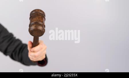 Donna che tiene il gavel del giudice su sfondo bianco. Foto Stock