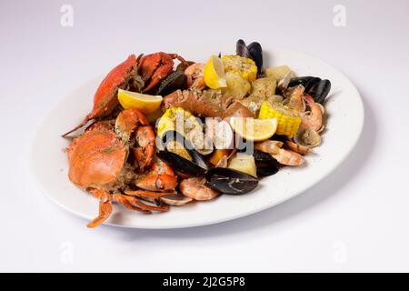 GRANCHIO E FRUTTI DI MARE CLAWDADY BOLLIRE in un piatto vista dall'alto su sfondo grigio Singapore cibo Foto Stock
