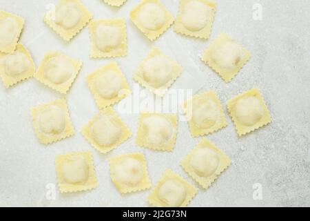 Ravioli crudi (gnocchi) disposti su sfondo grigio chiaro Foto Stock