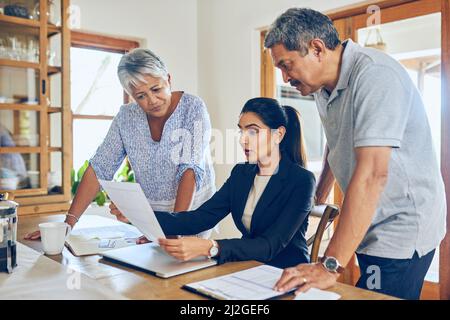 Abbiamo una gamma di portafogli di pensione in offerta. Shot di una coppia matura che ottiene il consiglio dal loro consulente finanziario nel paese. Foto Stock