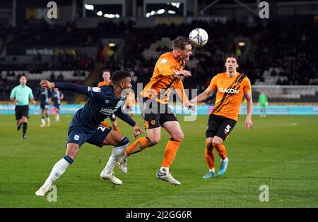 Il Sean McLoughlin di Hull City testa la palla davanti al Fraiser Campbell di Huddersfield Town durante la partita del campionato Sky Bet al MKM Stadium di Hull. Data foto: Venerdì 1 aprile 2022. Foto Stock