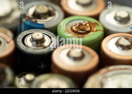 Primo piano della batteria usata con tracce di ruggine e corrosione. Concetto di rifiuti pericolosi elettronici Foto Stock