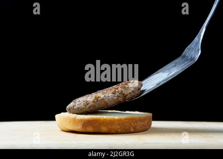 Mettere un hamburger cotto su un boccale di hamburger sul fondo in un ambiente studio. Foto Stock