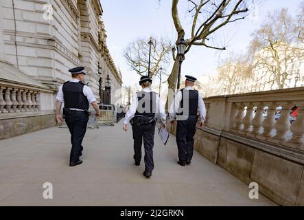 Metropolitan Police Force; tre poliziotti incontrati che camminano a Whitehall London SW1, vista posteriore, Central London UK Foto Stock