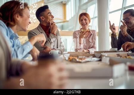 Gruppo multietnico di colleghi che fanno colazione in ufficio Foto Stock