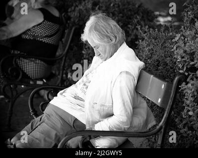 SOFIA, BULGARIA - 01 AGOSTO 2017: Uomo anziano seduto e addormentato su una panchina nel centro di Sofia (bianco-nero) Foto Stock