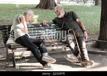 SOFIA, BULGARIA - 02 AGOSTO 2017: Due uomini di mezza età seduti su una panchina e giocando una partita di scacchi in un giardino della città di Sofia centro Foto Stock