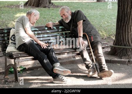 SOFIA, BULGARIA - 02 AGOSTO 2017: Due uomini di mezza età seduti su una panchina e giocando una partita di scacchi in un giardino della città di Sofia centro Foto Stock