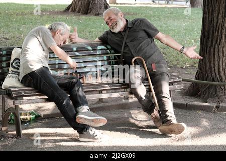 SOFIA, BULGARIA - 02 AGOSTO 2017: Due uomini di mezza età seduti su una panchina e giocando una partita di scacchi in un giardino della città di Sofia centro Foto Stock